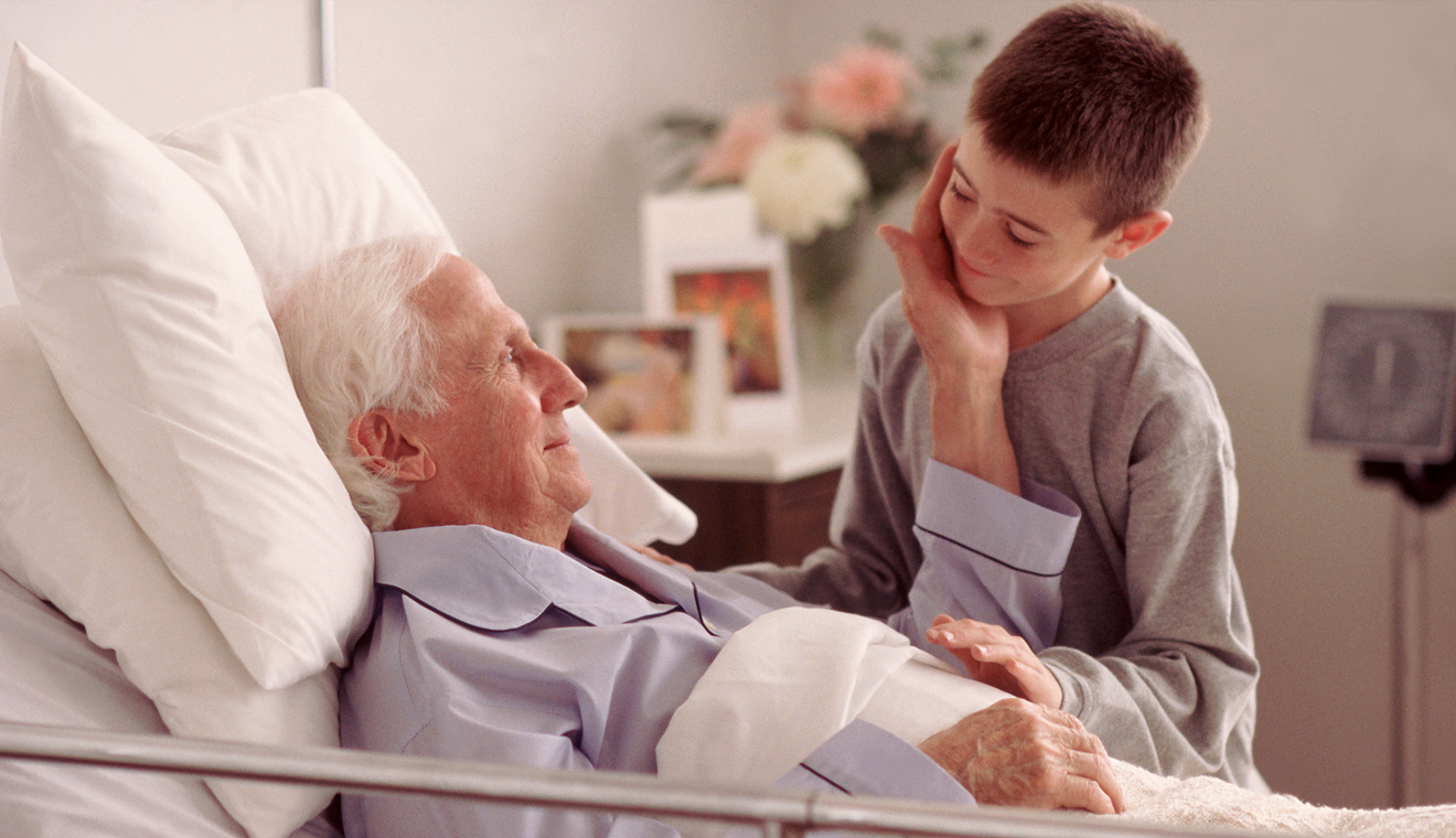 young boy at beside of male patient 