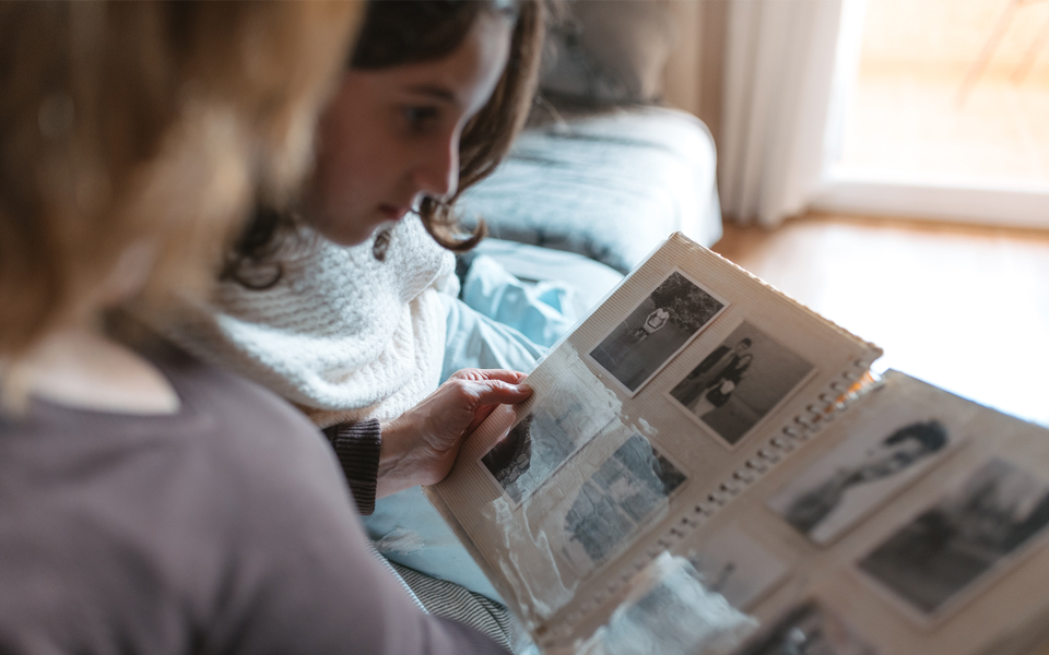 Person looking through a photo album while sitting indoors