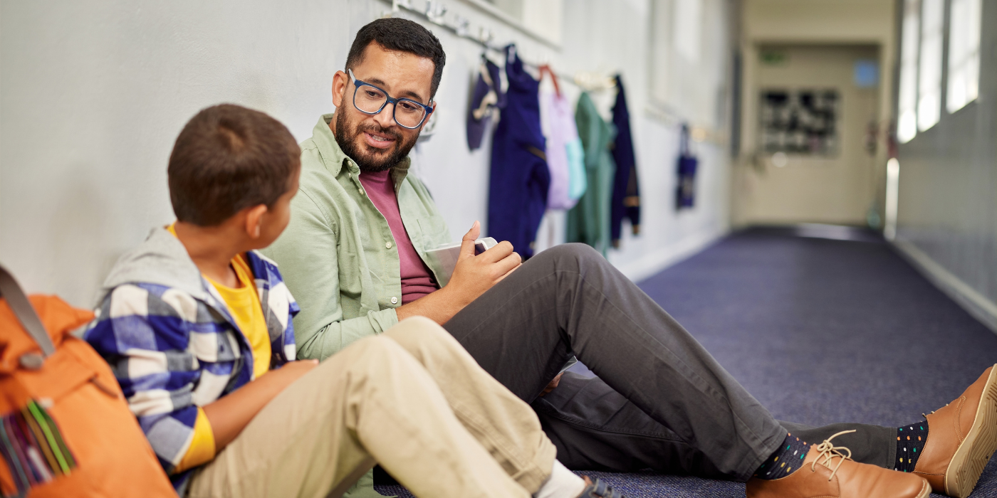 Man talking to child at school