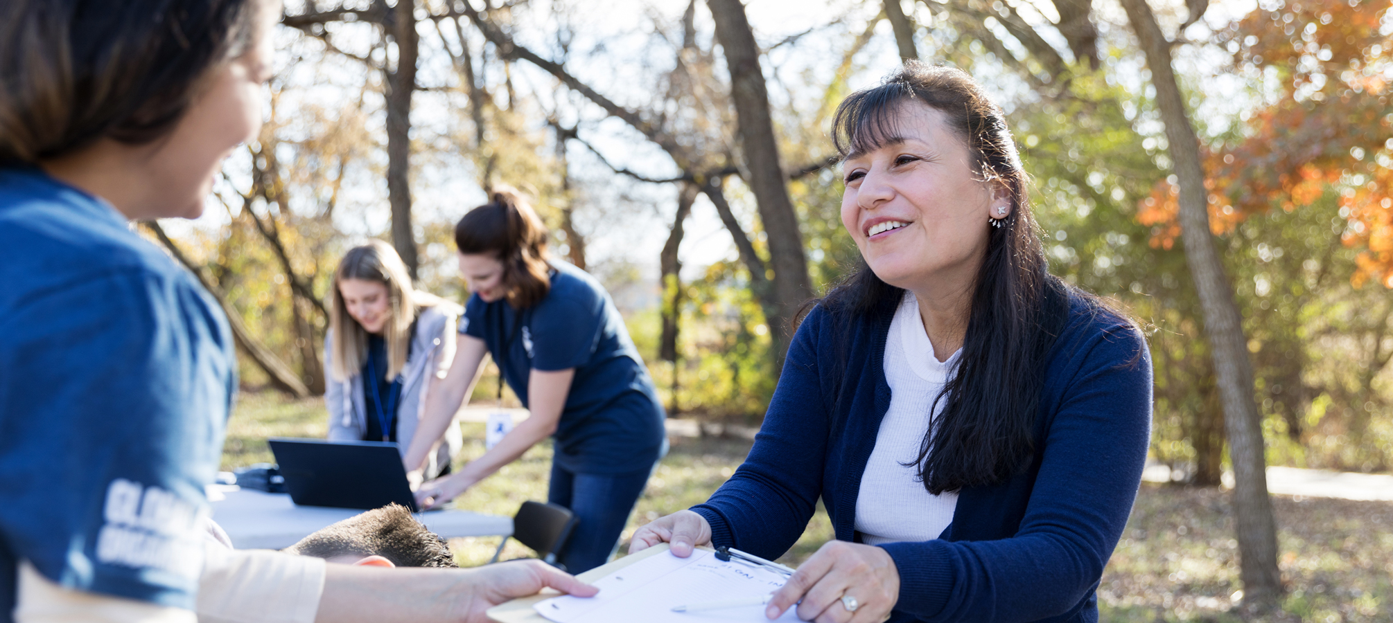 People talking and volunteering together outdoors.