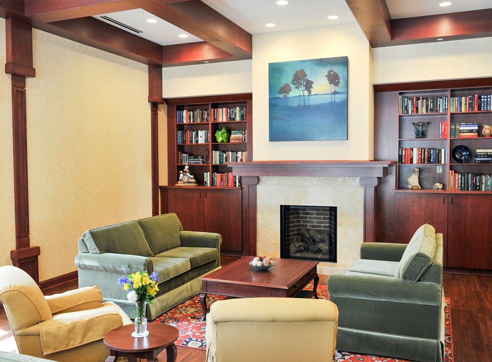 Comfortable sitting room with fireplace, bookshelves, and seating