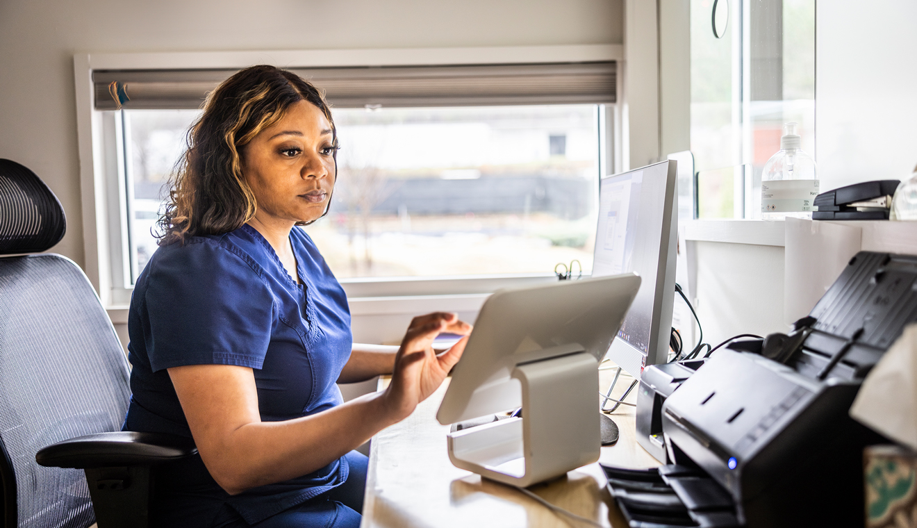 Healthcare professional coordinating care from a mobile office workspace.