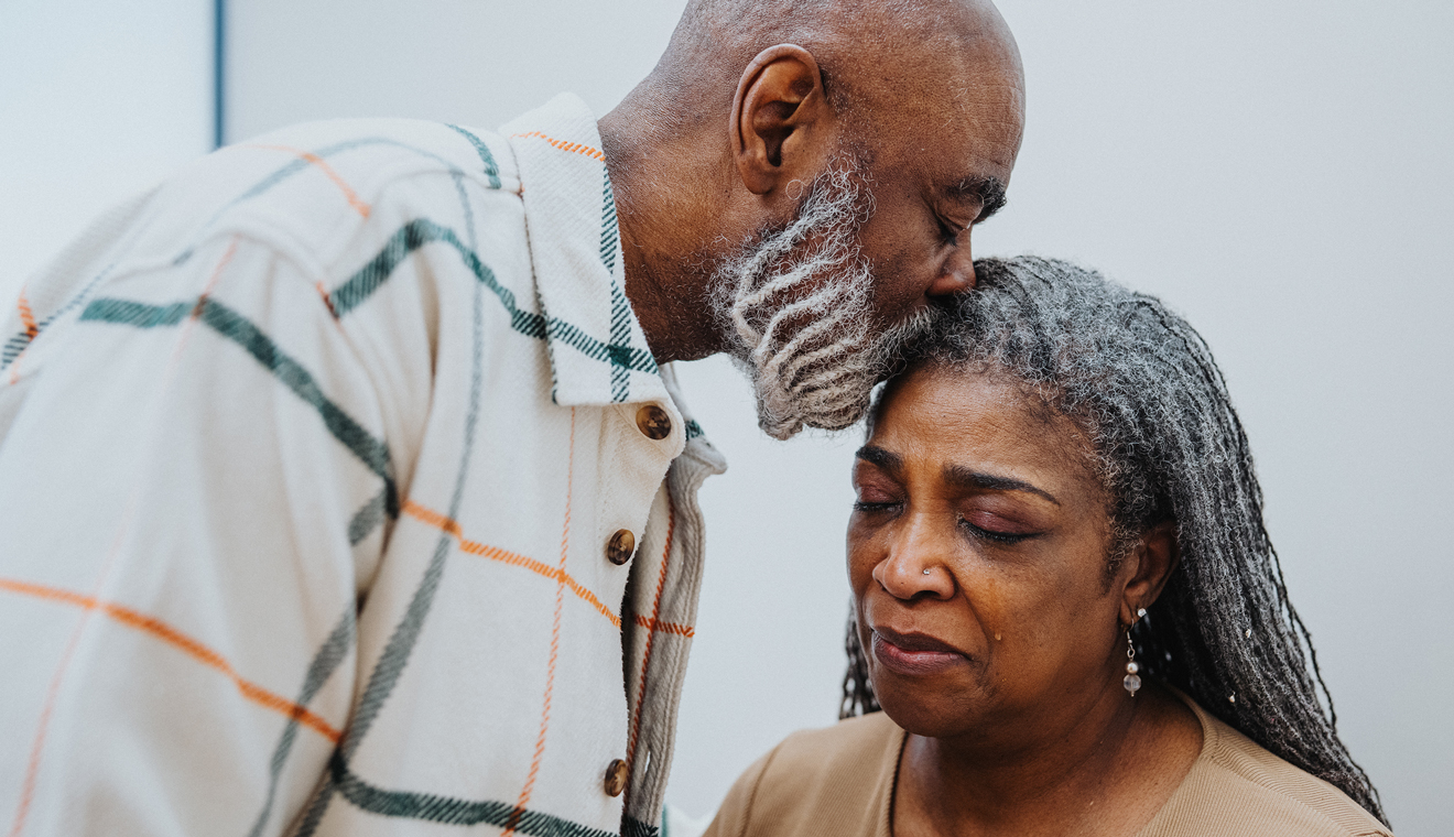 Man kissing woman's forehead