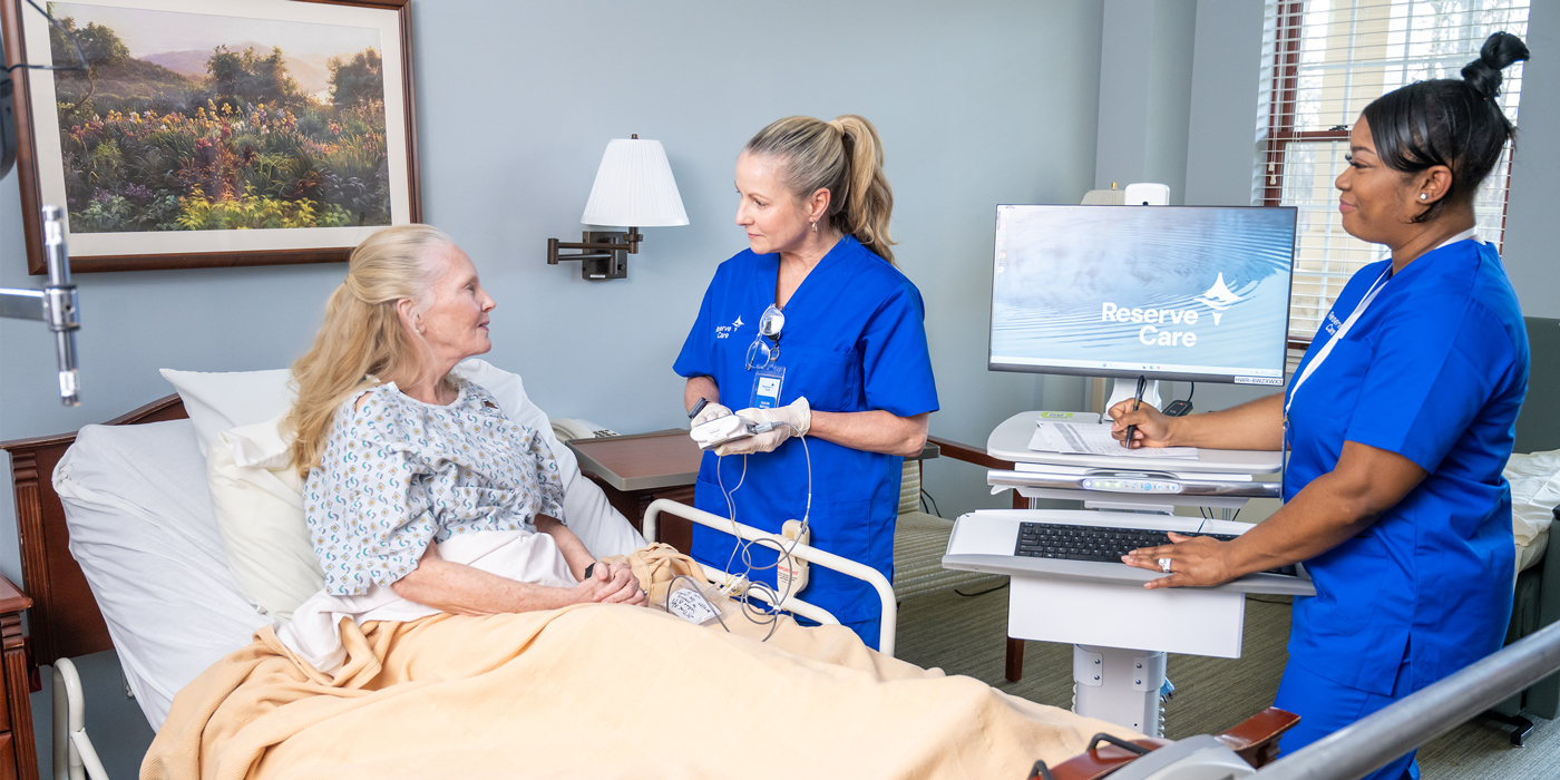 Hospice workers with patient with a computer