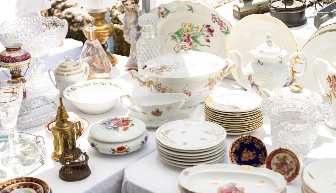 Table display with decorative dishes, glassware, and vintage household items
