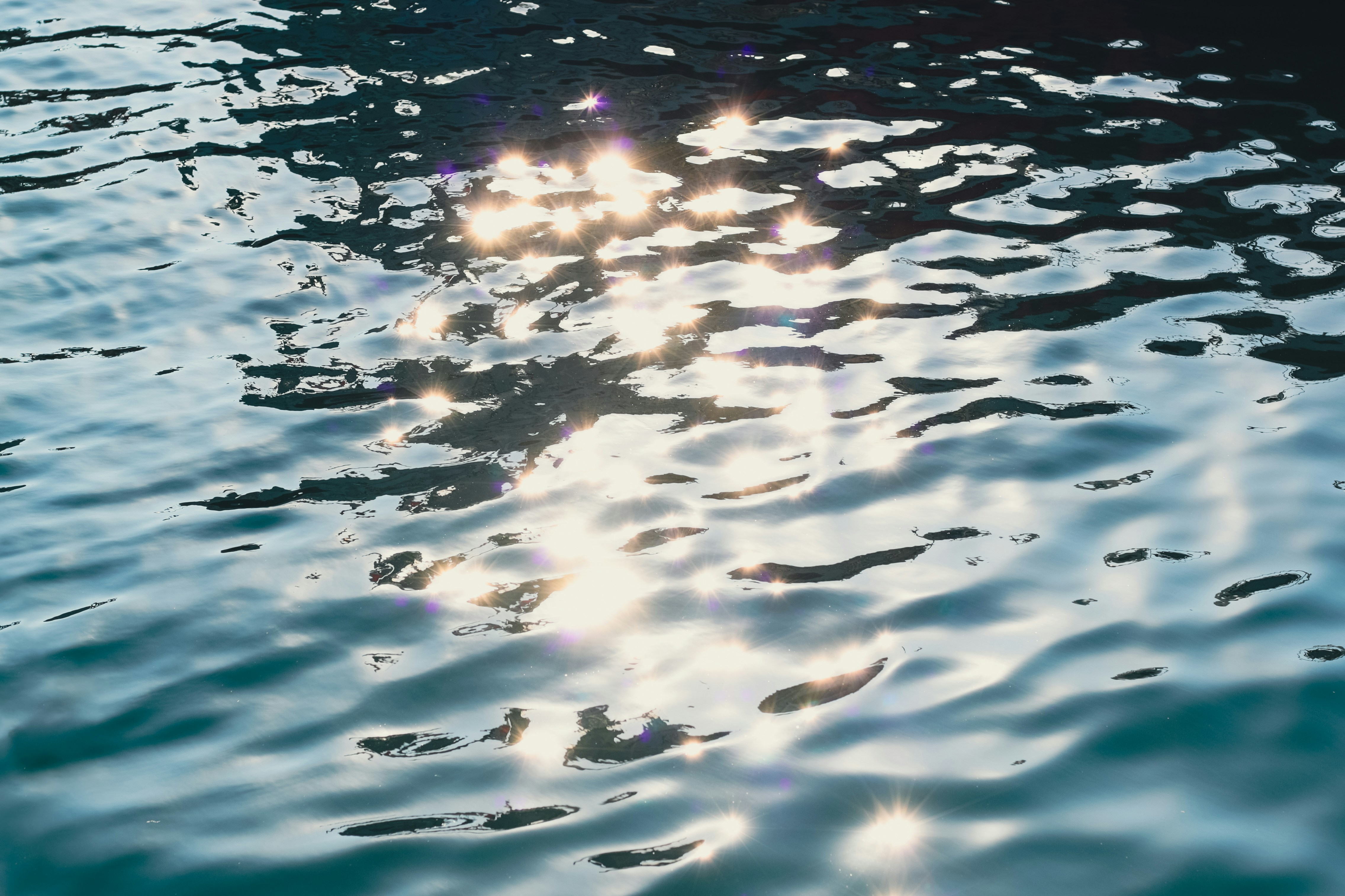 Sunlight reflecting across calm water, creating a peaceful and serene scene.